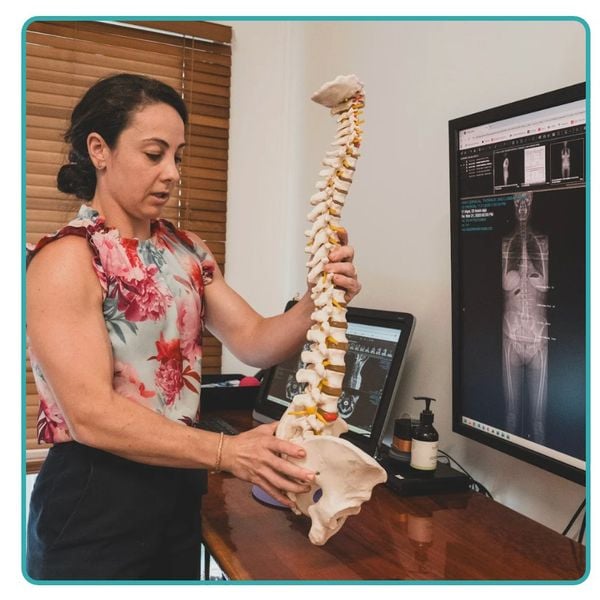 Chiropractor explaining spinal health with a spine model at Lifetime Chiro